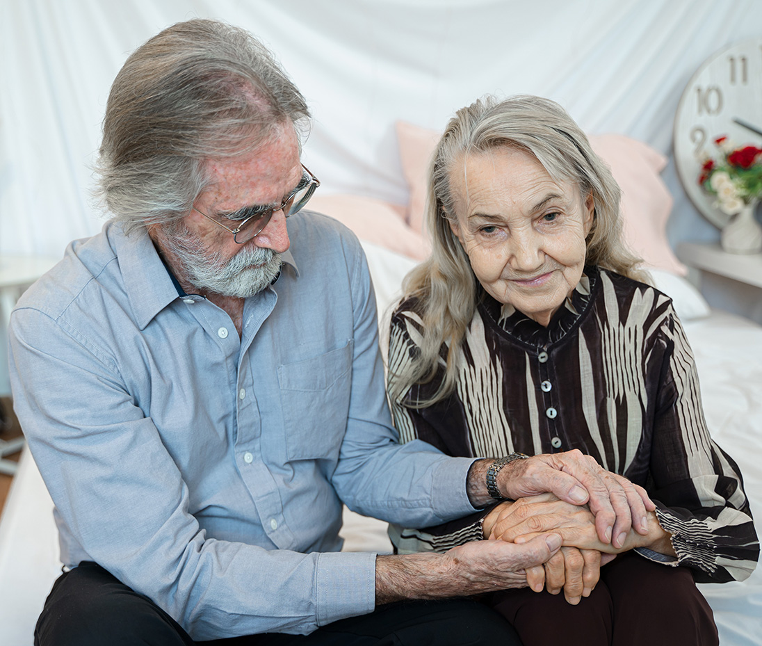 An older couple sitting together and holding hands